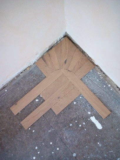 Detailaufnahme der Parkettverlegung in einer Ecke, mit einem kunstvollen Eckfries in Siebtel-Teilung aus Vollholz-Parkett, verlegt unter Anleitung von Wulf Frost von Boden-Frost Parkett.