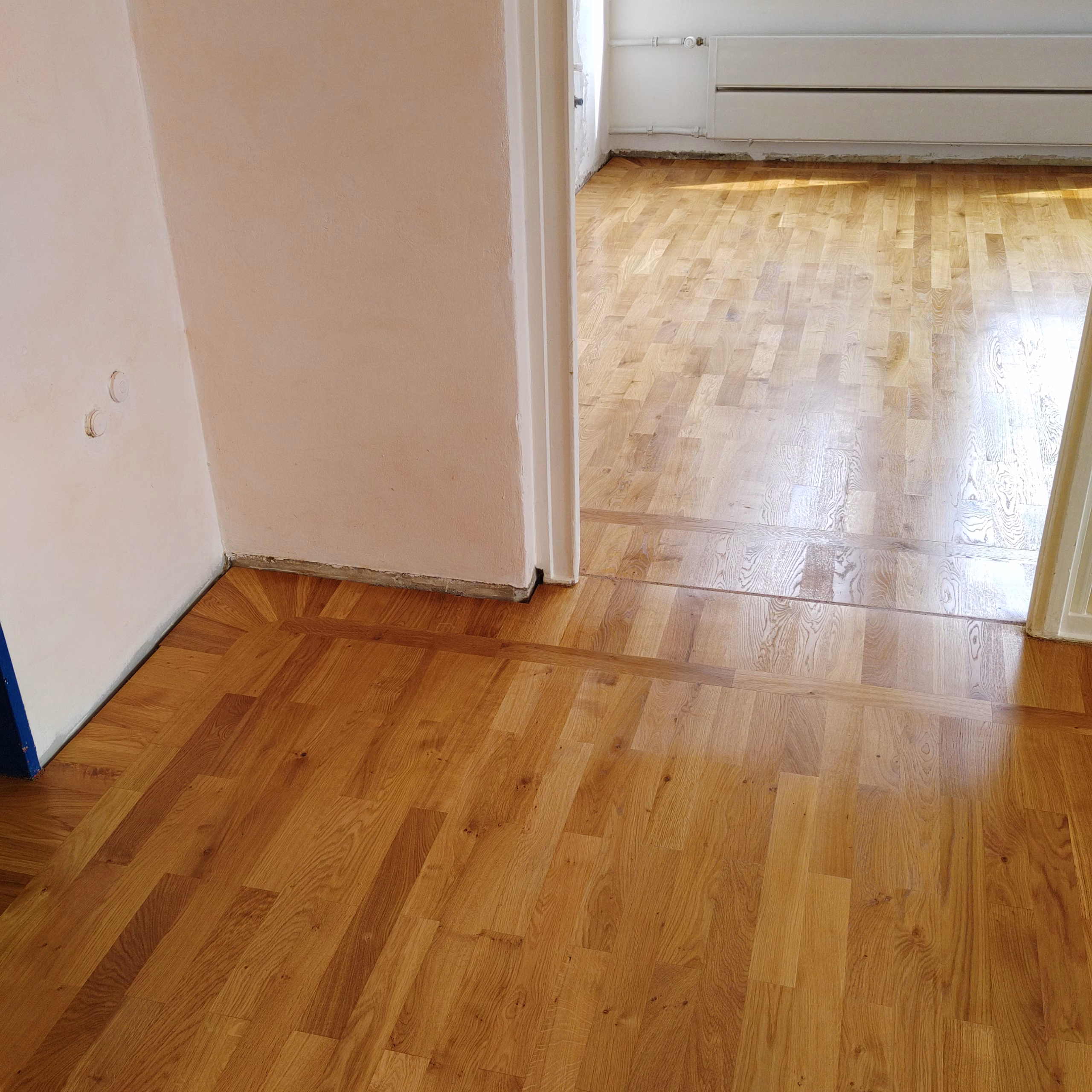 Professionell verlegtes Vollholzparkett in einem Eurythmieraum, mit Fries und siebtelgeteilten Ecken, ausgeführt von Boden-Frost Parkett unter Anleitung von Wulf Frost in Osterholz-Scharmbeck.